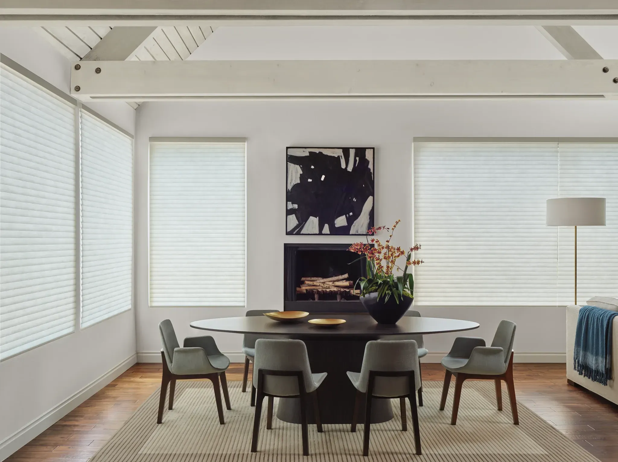 Bright dining room with cellular window shades and a fireplace