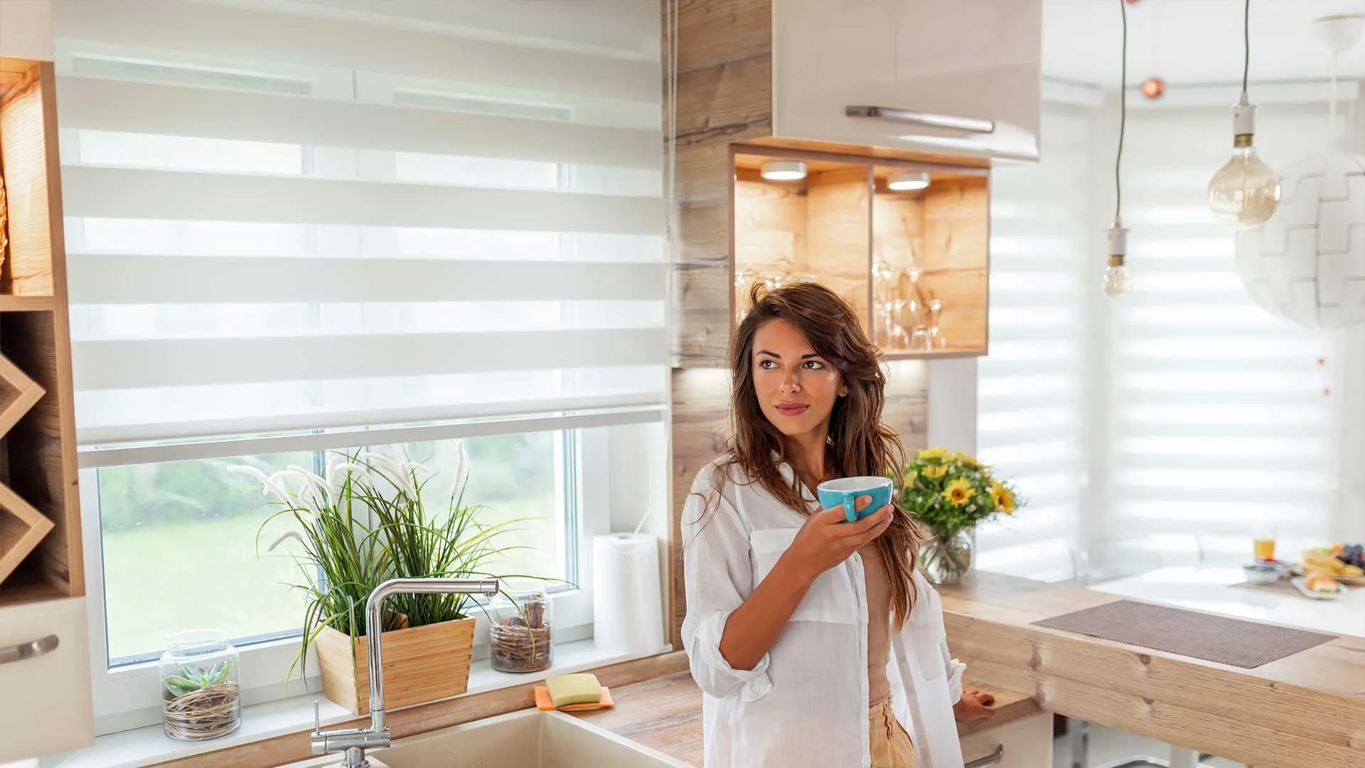 Sheer zebra roller shades in a bright, modern kitchen